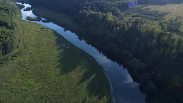 Vista aérea: Voo sobre o belo rio e a madeira verde. Pôr do sol luz suave com céu nublado pastel. Paisagem mágica. Resolução 4K . — Vídeo de Stock