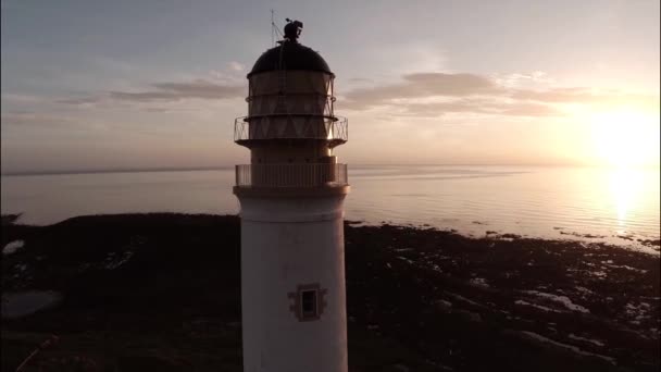 Aerial shot of a lighthouse during a beautiful sunrise in Scotland — Stock Video