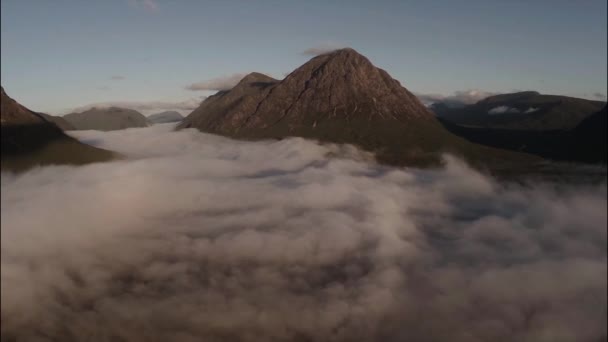 Antenn skott genom molnet inversion avslöjar buachaille etive mor berg under sunrise — Stockvideo