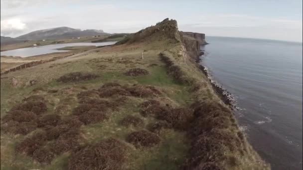 Plano aéreo cinematográfico mirando por encima del borde de un acantilado en Skye en Escocia — Vídeo de stock