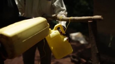 Afrikalı bir köyde handwash istasyonu bir adamı bir su şişesi doldurma olarak kullanılan