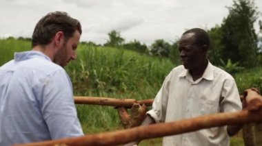 Beyaz adam bir su de Uganda'da Afrika Afrika adam sohbet