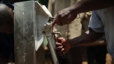 Bir su bakımı iki Afrika adam kırsal Masindi, Uganda, Eylül 2013 de.