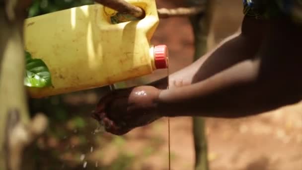 Eine afrikanische Dame mit einer Handwaschstation aus Plastikbehältern — Stockvideo