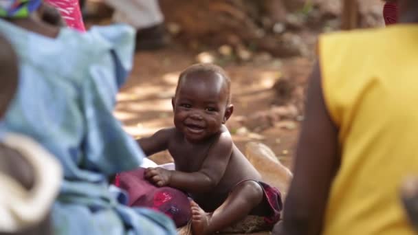 A young African child sitting smiling amoung others, Moshi, Kenya, March 2013 Royalty Free Stock Footage