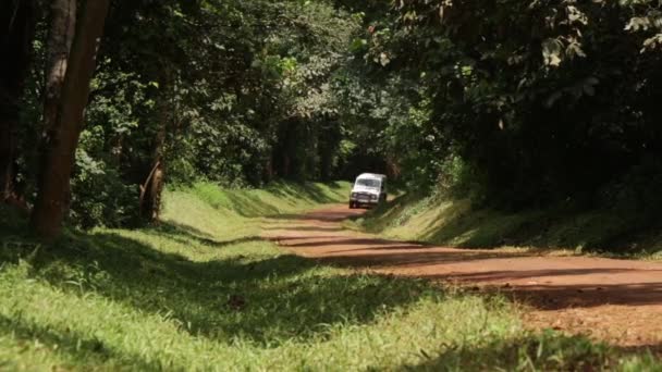Ландровер едет по сельской дороге в Масинди, Уганда, сентябрь 2013 года — стоковое видео