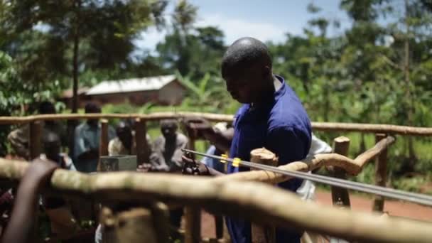 Seorang pria Afrika dengan pipa baja yang digunakan untuk memasang sumur baru di pedesaan Masindi, Uganda, September 2013 — Stok Video