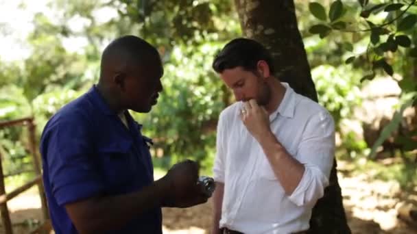 Un uomo caucasico che chiacchiera con il meccanico africano sull'installazione di un nuovo pozzo nel villaggio, Masindi, Uganda, settembre 2013 — Video Stock