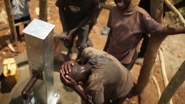 Glada afrikanska barn firar installationen av en ny vatten bra i sin by, Masindi, Uganda, September 2013 — Stockvideo