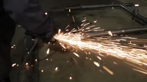 Man met een molen in een metalen workshop met een heleboel vonken — Stockvideo