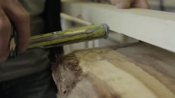 Hombre usando una cinta métrica para marcar un punto en un pedazo de madera — Vídeos de Stock