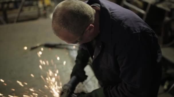 Mann mit einem Schleifer in einer Metallwerkstatt mit vielen Funken, Schild, England, Oktober 2014 — Stockvideo