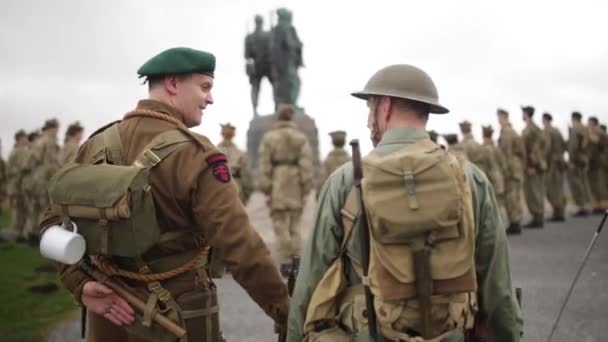 Diferentes soldados ficam em torno do memorial de guerra sorrindo com rifle, Spean Bridge, Escócia, maio de 2014 — Vídeo de Stock
