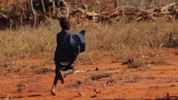 Ребенок масаи, бегущий на открытой местности, Тавета, Кения, март 2013 года — стоковое видео