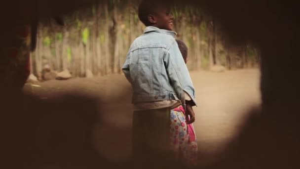 Niño africano jugando con hermana buscando inquisitivo, Taveta, Kenia, marzo 2013 — Vídeo de stock