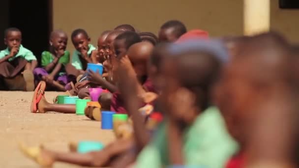 Young African children drinking from large plastic cups, Kenya, March 2013 — Stock Video