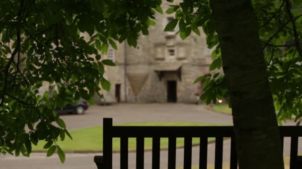 Slider shot of a bench with a tree in foreground and a castle in the background. Shot in Scotland — Stock Video