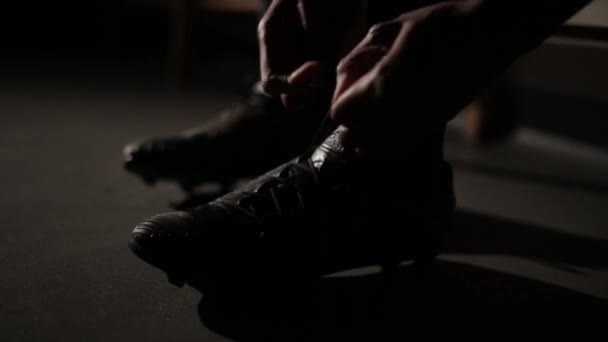 Footballeur attachant ses lacets se préparer pour un match. Tournage cinématographique avec fusée éclairante — Video