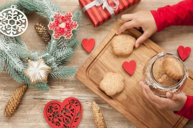 Noel ve Yeni Yıl arkaplanlarında, köknar ağacıyla süslenmiş Noel yemekleri pişirmek için malzemeler var. Yeni yıl dekoru, ev yapımı kurabiyeler ve tatil için hazırlanan çocukların elleri..