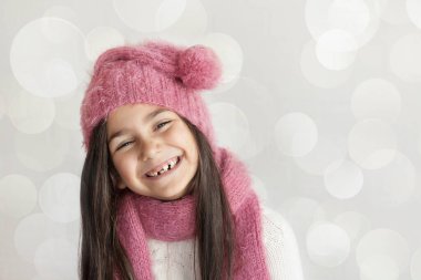 Pembe örgü atkı ve şapkalı güzel bir kızın portresi.