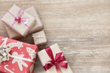 Noel arkaplanında hediye kutuları ve ahşap arka planda Noel süsleri.