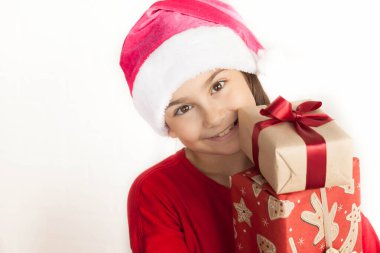 Noel Baba şapkalı küçük kız elinde hediye kutuları tutuyor.