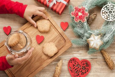 Noel ve Yeni Yıl arkaplanlarında, köknar ağacıyla süslenmiş Noel yemekleri pişirmek için malzemeler var. Yeni yıl dekoru, ev yapımı kurabiyeler ve tatil için hazırlanan çocukların elleri..