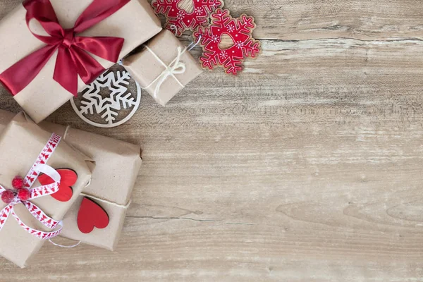 Noel arkaplanında hediye kutuları ve ahşap arka planda Noel süsleri.