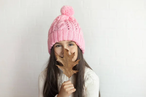 Porträt Eines Schönen Kleinen Mädchens Mit Rosa Strickmütze Und Herbstblatt — Stockfoto