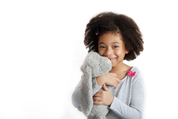 восхитительная маленькая девочка, держащая милую игрушку зайчика в студии