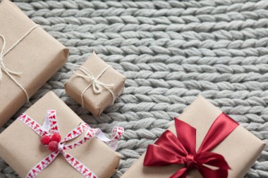 Örgü arka planda kurdeleli hediye kutuları. Noel ve yeni yıl hediyeleri. Doğum günü tebrikleri ve hediyeleri.