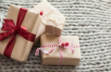 Örgü arka planda kurdeleli hediye kutuları. Noel ve yeni yıl hediyeleri. Doğum günü tebrikleri ve hediyeleri.