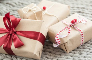 Örgü arka planda kurdeleli hediye kutuları. Noel ve yeni yıl hediyeleri. Doğum günü tebrikleri ve hediyeleri.