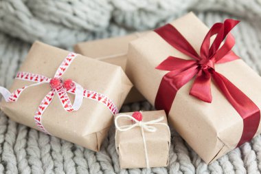 Örgü arka planda kurdeleli hediye kutuları. Noel ve yeni yıl hediyeleri. Doğum günü tebrikleri ve hediyeleri.