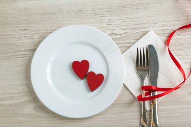 Sevgililer Günü konsepti. Ahşap arka planda kalp şeklinde çatal bıçak seti olan masa ayarları
