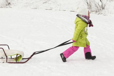 Güzel kız karda oynuyor. 
