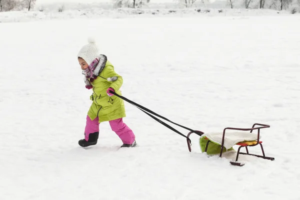 little girl playing on snow yard