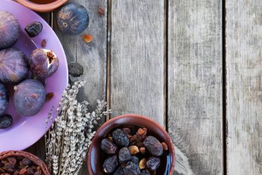 Kurumuş tarihli taze incirler ve ahşap arka planda kurutulmuş lavanta.