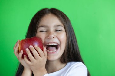 Asyalı kız yeşil elma yiyor.