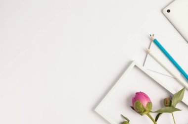 Beyaz arkaplanda pembe güllerin ve defterin üst görünümü