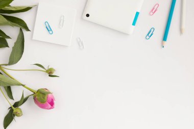 Boş not defteri, pembe arka planda kalem ve kahve ile ofis masasının üst görüntüsü