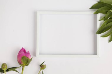 Gri arkaplan üzerinde çiçekler olan beyaz boş çerçeve