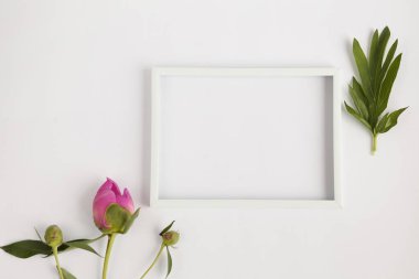 Yeşil zemin üzerinde çiçekler olan beyaz boş çerçeve