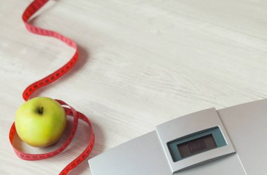 Elma ve mezura tahta masada.