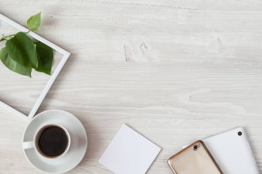 Kahvenin ve tabletin ahşap masanın üzerinde boş bir defter ile üst görüntüsü