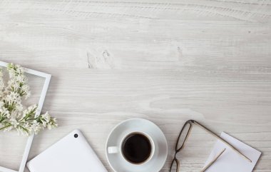 Kahvenin ve tabletin en üst görüntüsü ve ahşap masada bir fincan çay.