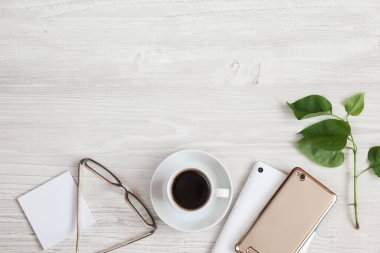 Beyaz ahşap masa üzerinde boş ekranlı kahve ve tabletin üst görüntüsü