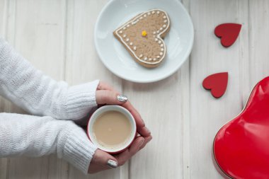 Tahta masada bir fincan kahve ve kalp şeklinde.