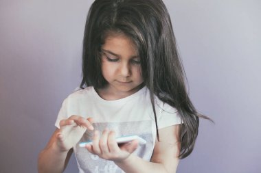 Akıllı telefon kullanan küçük kız. 