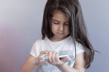 Akıllı telefon kullanan küçük kız. 